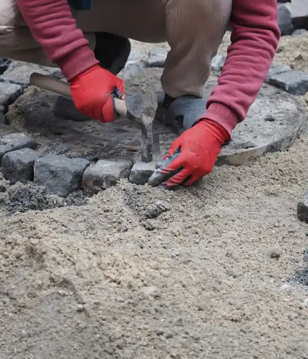worker-adds-stones-to-a-circular-area-on-a-constru-2026-01-15-23-37-41-utc